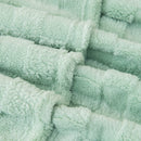 Detailed view of a cosy green blanket is perfect for a stylish and inviting bedroom atmosphere.