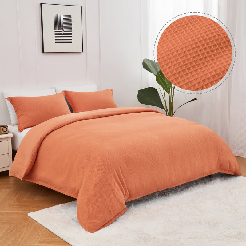 alt="An orange quilt cover set features a cotton waffle weave design"