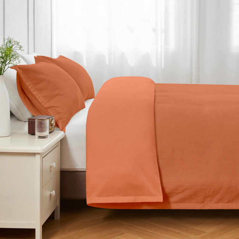 alt="Side view of an orange quilt cover set featuring a cotton waffle weave design"