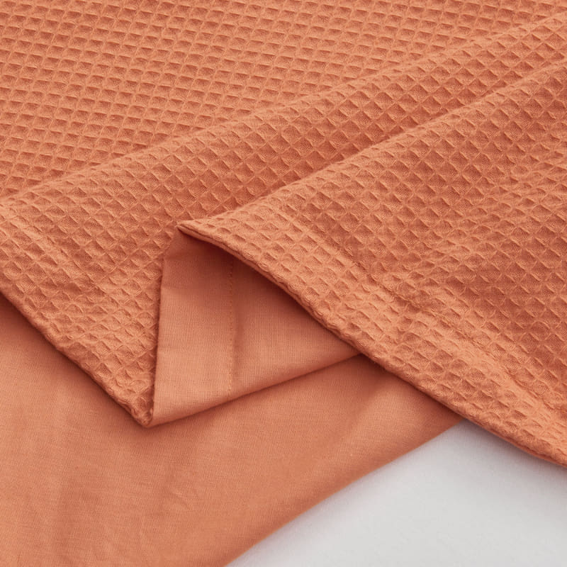 alt="Zoom in details of an orange quilt cover set featuring a cotton waffle weave design"