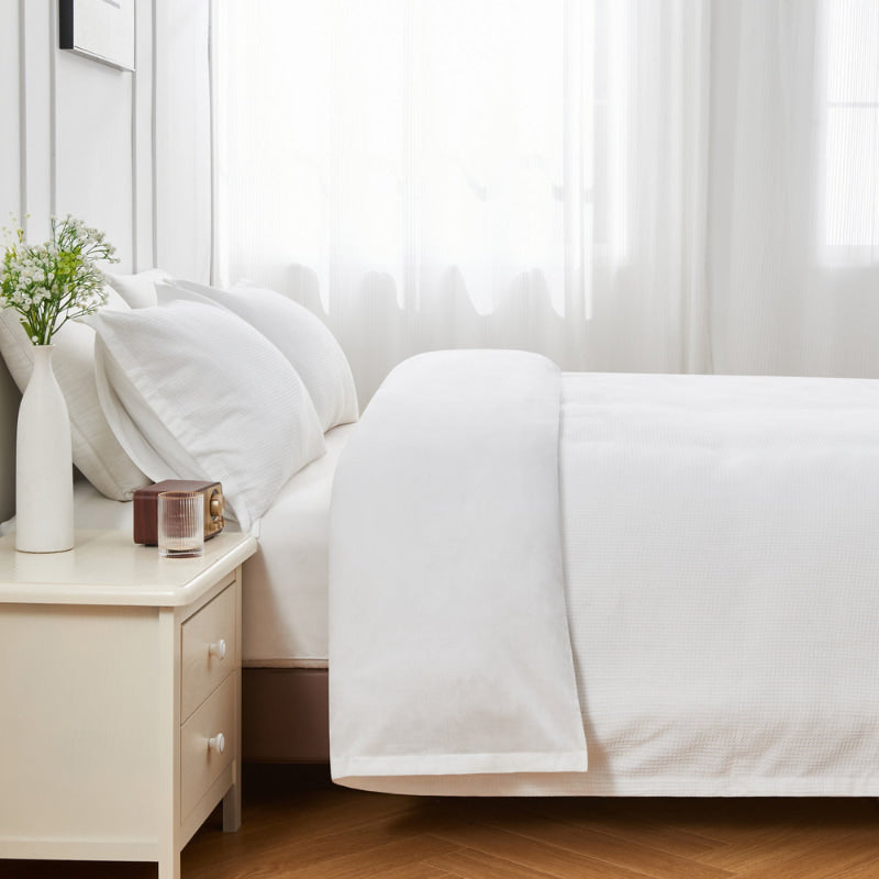 alt="Side view of a white quilt cover designed to provide comfort and style to your bedroom."