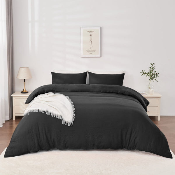 alt="Black Linenova quilt cover set neatly laid on a bed, showcasing its elegant and soft appearance."