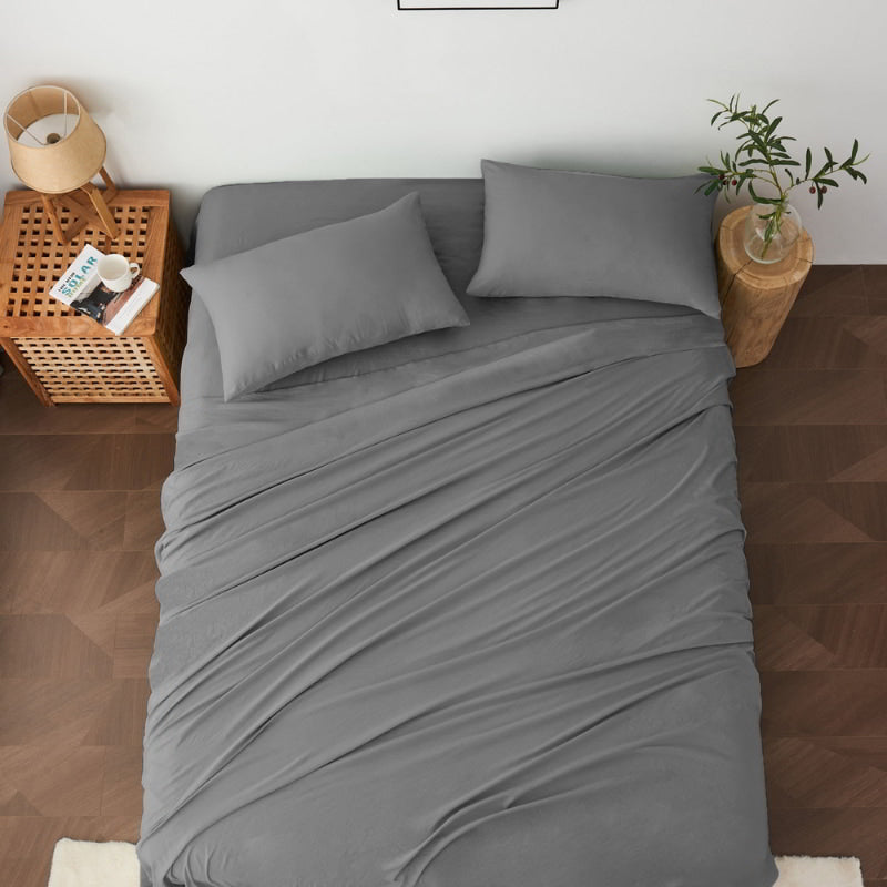 alt="A luxuriously soft charcoal cotton pre-washed sheet set in a cosy bedroom"