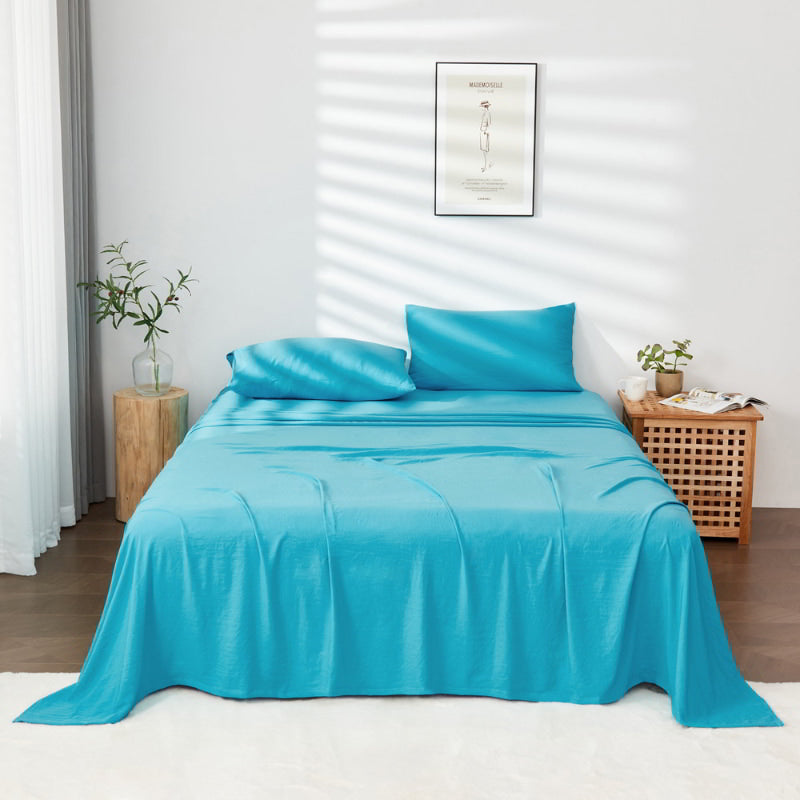 alt="A luxuriously soft turquiose cotton pre-washed sheet set in a cosy bedroom"