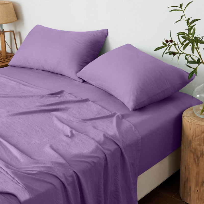 alt="A luxuriously soft lilac cotton pre-washed sheet set in a cosy bedroom"