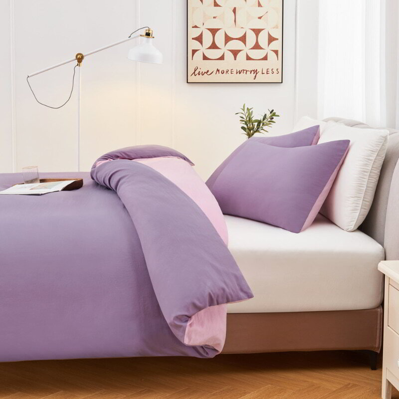alt="Side view of a lilac Linenova quilt cover set neatly laid on a bed, showcasing its elegant and soft appearance."