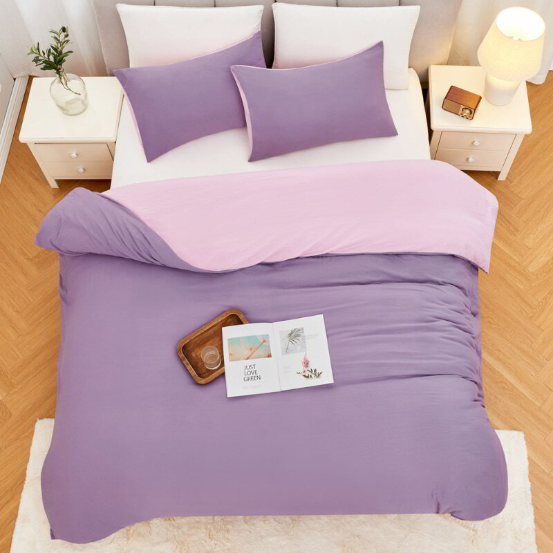 alt="Top view of a lilac Linenova quilt cover set neatly laid on a bed, showcasing its elegant and soft appearance."