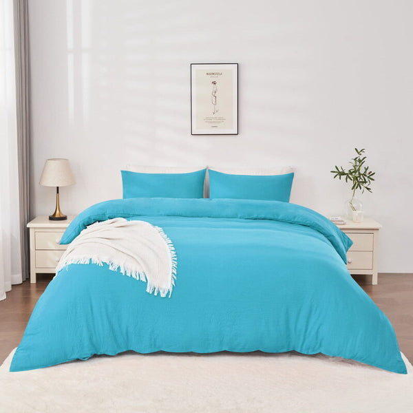 alt="Blue Linenova quilt cover set neatly laid on a bed, showcasing its elegant and soft appearance."