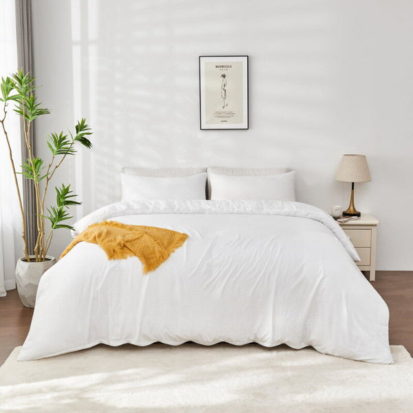 alt="White Linenova quilt cover set neatly laid on a bed, showcasing its elegant and soft appearance."
