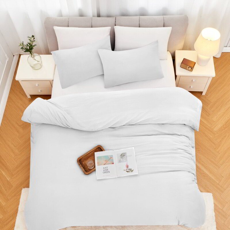 alt="Top view of a white linenova quilt cover set neatly laid on a bed, showcasing its elegant and soft appearance"