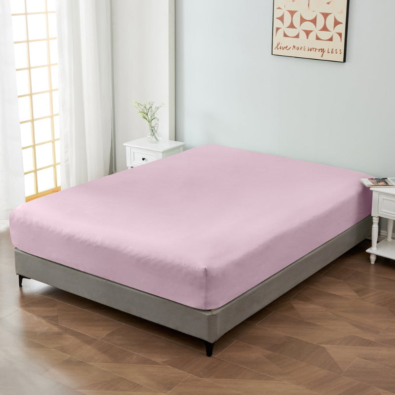 alt="A luxuriously soft 100% cotton pink fitted sheet with deep pocket in a cosy bedroom"