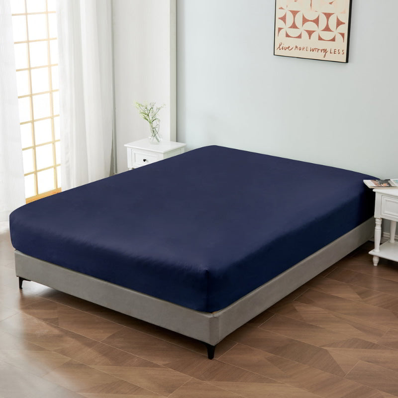 alt="A luxuriously soft 100% cotton navy fitted sheet with deep pocket in a cosy bedroom"