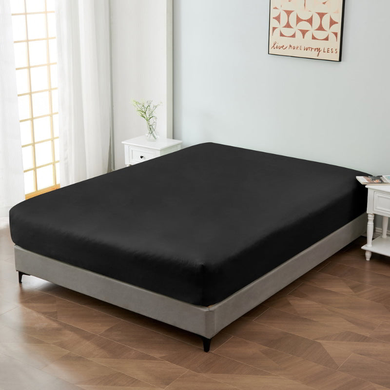 alt="A luxuriously soft 100% cotton black fitted sheet with deep pocket in a cosy bedroom"