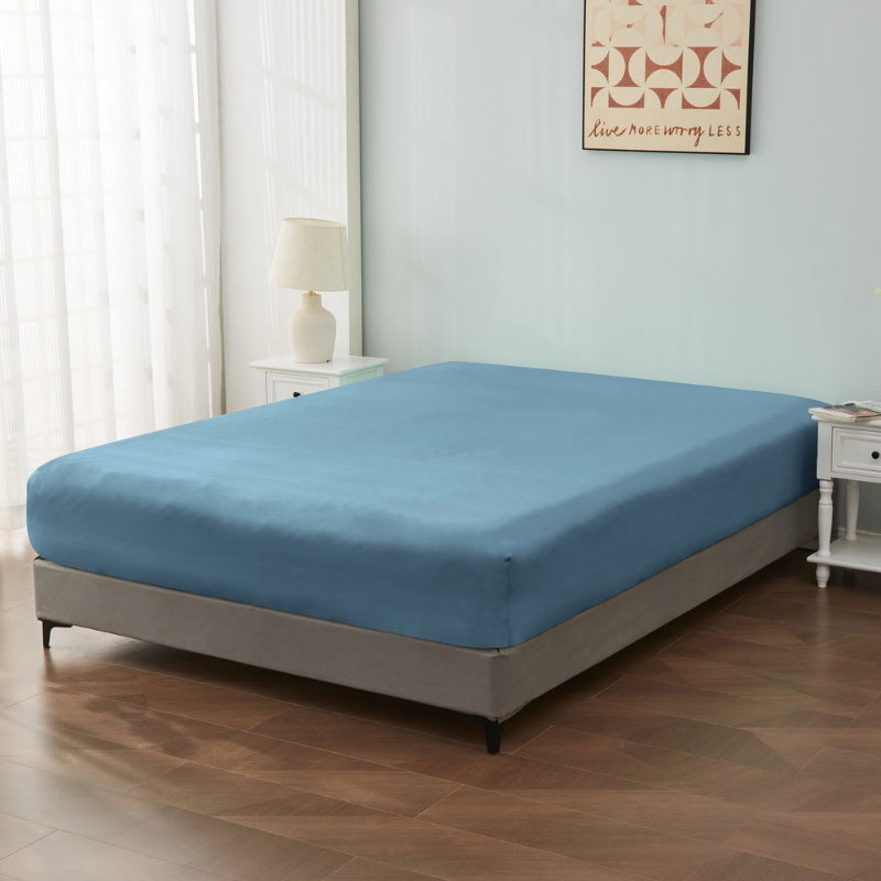 alt="An ultra-soft cotton blend dusty blue fitted sheet with deep pocket in a cosy bedroom"