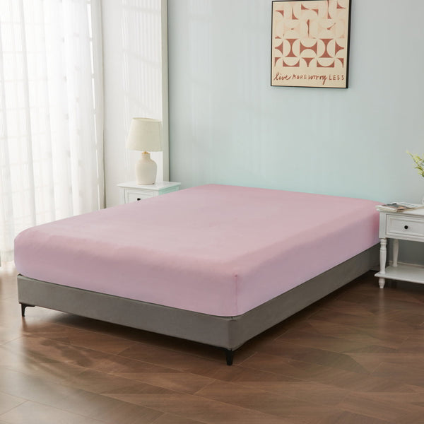 alt="An ultra-soft cotton blend light pink fitted sheet with deep pocket in a cosy bedroom"