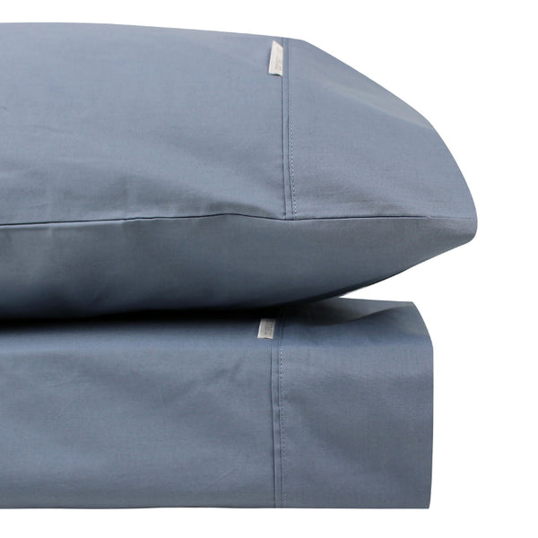 alt="Close-up look of a steel blue sheet set made from 100% cotton showcasing fresh appearance, ultimate softness and cottony comfort"