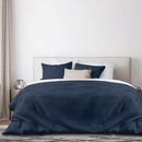 Florida Keys Waffle Navy Quilt Cover Set styled on a bed with white and navy pillows.

