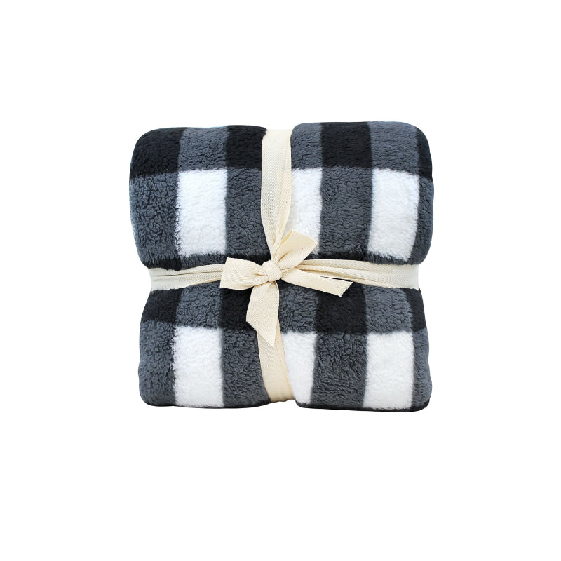 Front packaging details of a cosy bed with a charcoal and white blanket featuring a large checkered pattern creates a bold visual grid, adding colour and pattern to the room's decor.