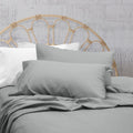 A clean and classic grey bed with matching sheets and pillows on a cosy bedroom, made of 100% microfibre for a soft and warm feel.