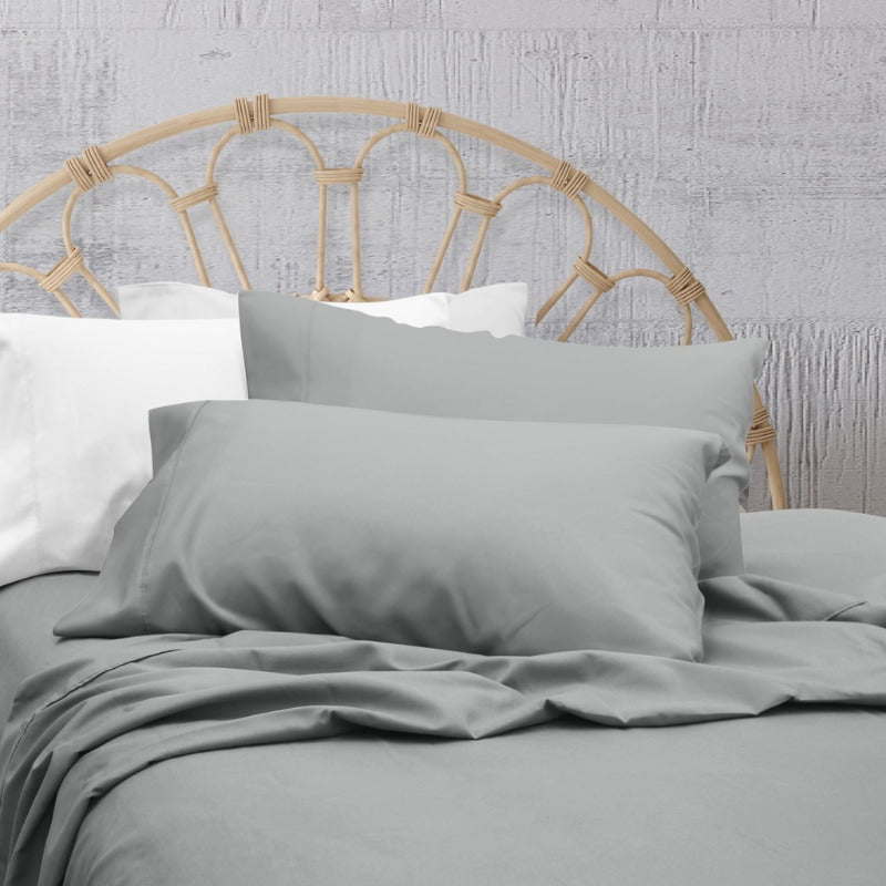 A clean and classic grey bed with matching sheets and pillows on a cosy bedroom, made of 100% microfibre for a soft and warm feel.