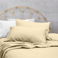 A clean and classic natural-toned bed with matching sheets and pillows on a cosy bedroom, made of 100% microfibre for a soft and warm feel.