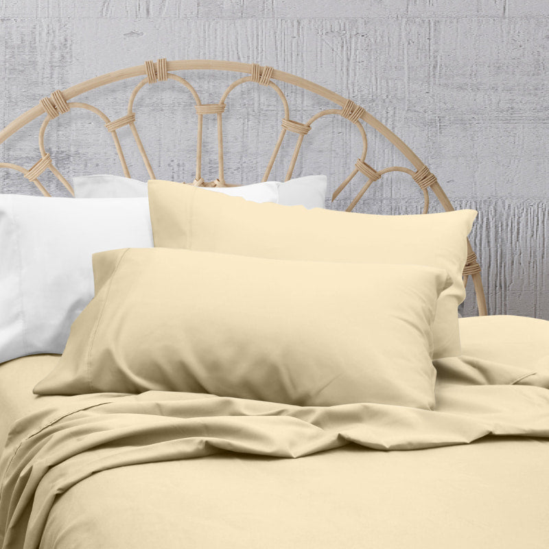 A clean and classic natural-toned bed with matching sheets and pillows on a cosy bedroom, made of 100% microfibre for a soft and warm feel.