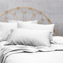 A clean and classic white bed with matching sheets and pillows on a cosy bedroom, made of 100% microfibre for a soft and warm feel.