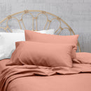 A clean and classic orange bed with matching sheets and pillows on a cosy bedroom, made of 100% microfibre for a soft and warm feel.