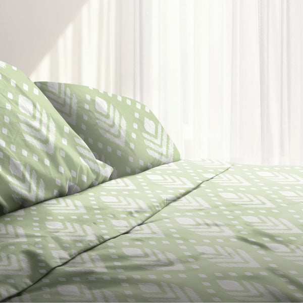 A bed with green and white bedding, featuring a trendy geometric pattern. Made of 100% microfibre for superior comfort and versatile styling.