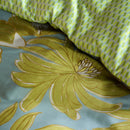 Fresh green and blue floral bedding set paired with light purple bedside lamp