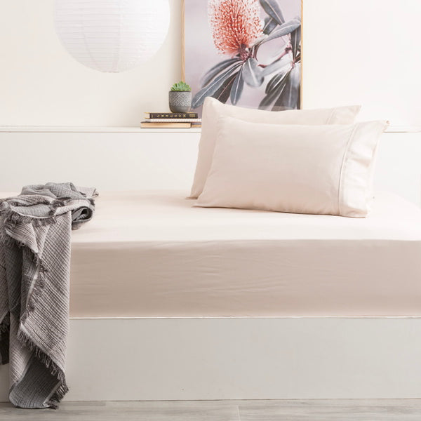 alt="A shade of dove fitted sheet and pillow on a bed, made with a soft bamboo cotton blend for a luxurious sleeping experience."