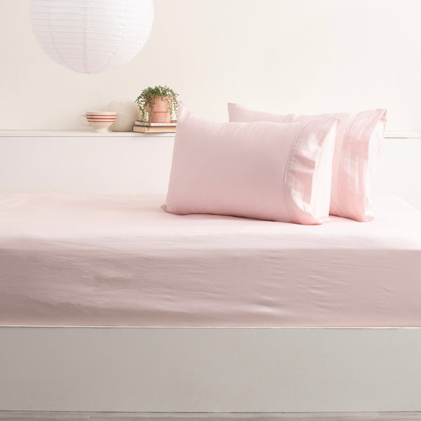 alt="Experience the ultimate comfort with this peach bamboo cotton fitted and pillowcase, featuring a silky smooth texture and 500 thread count."
