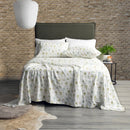 Park Avenue Capri Palm flannelette sheet set styled on a bed with white pillows and earthy decor