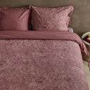 alt="Side view of an elegant Casa dei Fiori quilt cover with intricate floral designs, and a reversible print of tiny flowers."