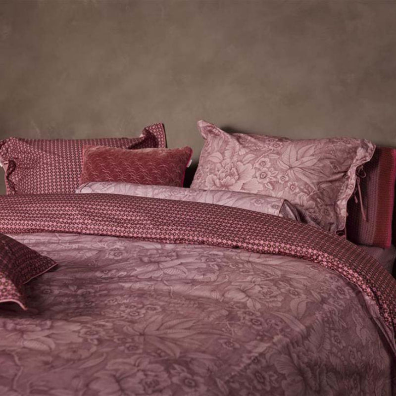 alt="Side view of an elegant Casa dei Fiori quilt cover with intricate floral designs, and a reversible print of tiny flowers."