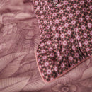 alt="Close up look of an elegant Casa dei Fiori quilt cover with intricate floral designs, and a reversible print of tiny flowers with the presence of pillow."