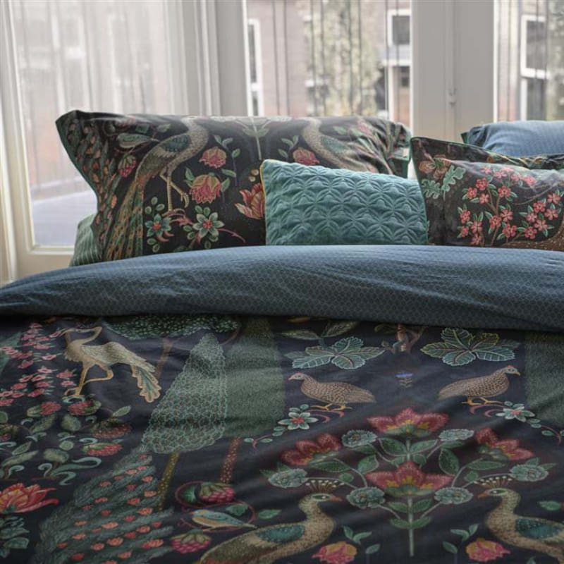 alt="Close up look of a mirror design quilt cover with ornate peacocks, wildlife, and vibrant flowers paired with pillowcases"