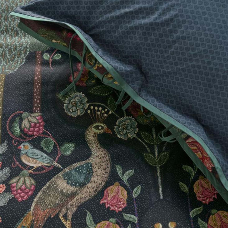 alt="A mirror design quilt cover with ornate peacocks, wildlife, and vibrant flowers.