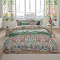 alt="Premium cotton quilt cover with ornate mirrored design and reversible foliage pattern in a cosy bedroom"
