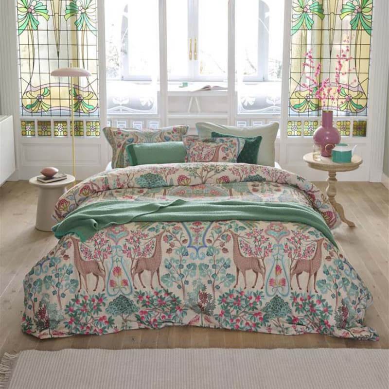 alt="Premium cotton quilt cover with ornate mirrored design and reversible foliage pattern in a cosy bedroom"