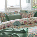 alt="Premium cotton quilt cover with ornate mirrored design and reversible foliage pattern in a cosy bedroom paired with pillowcases and blanket"