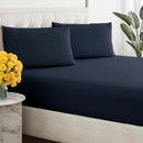 Close-up of a smooth, dark blue, breathable cotton sheet draped over a tufted bed base