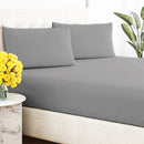 Close-up of a smooth, grey, breathable cotton sheet draped over a tufted bed base