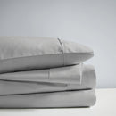 A stack of dove sheet set, showcasing the luxurious 700 Thread Count Renee Taylor Sheet Set.