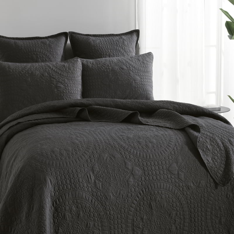 alt="A shade of grey coverlet set and pillowcases draw inspiration from the ornate detailing of traditional Greek tile patterns."
