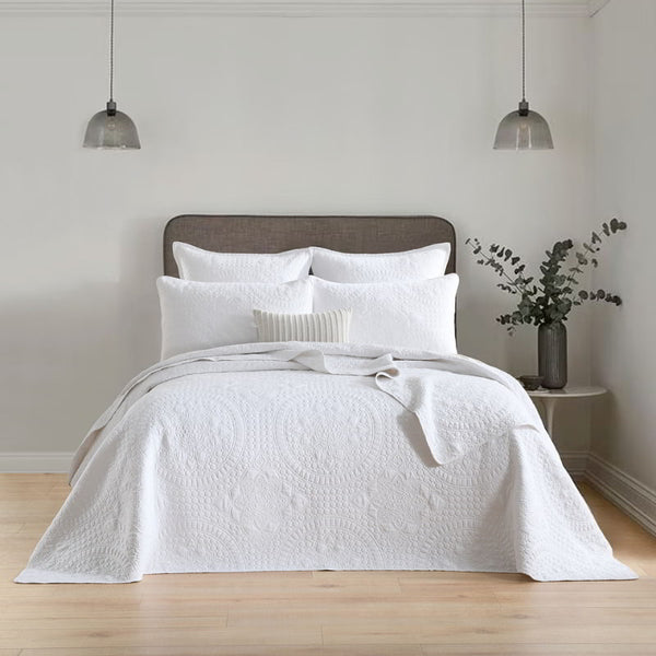 alt-"Showcasing a white coverlet draws inspiration from the ornate detailing of traditional Greek tile patterns."