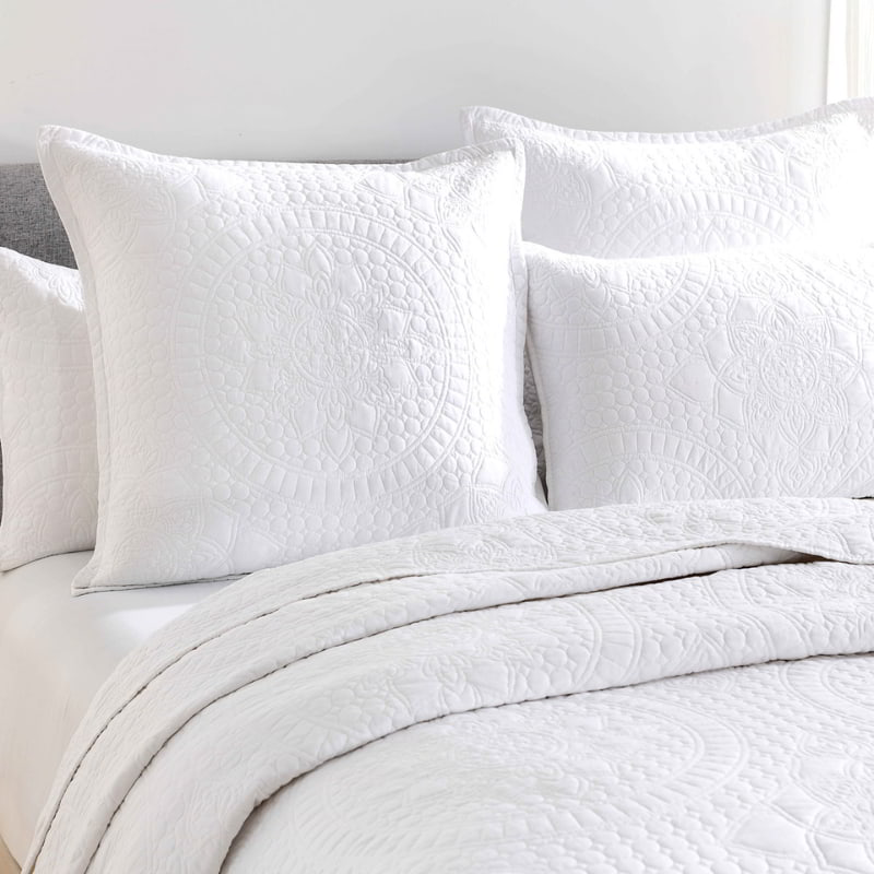 alt-"Showcasing a white coverlet and euopean pillowcase draw inspiration from the ornate detailing of traditional Greek tile patterns."