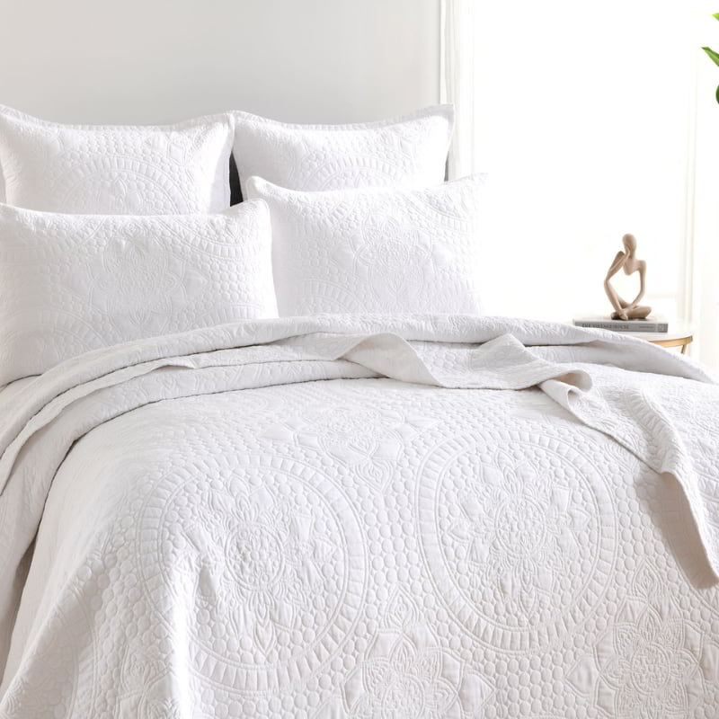 alt="A white european pillowcase features an inspiration from the ornate detailing of traditional Greek tile patterns pairing with the quilt cover in a cosy bedroom.