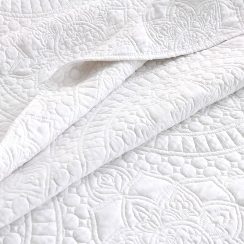 alt="Zoom in details of a white quilt cover features an inspiration from the ornate detailing of traditional Greek tile patterns.