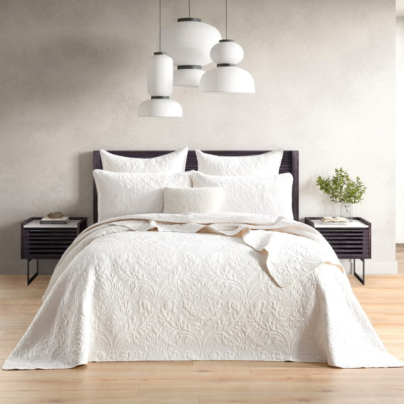 alt="Sophisticated white bed featuring a damask woven coverlet set and european pillowcase with a textured pattern and a stunning crinkle stripe effect."